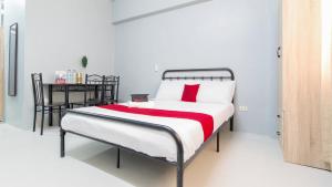 a bedroom with a bed with a red and white blanket at RedDoorz @ Sunfields Lipa Batangas in Lipa