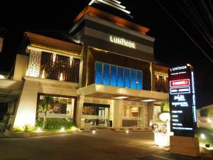 Un edificio con un cartel delante por la noche. en Luminor Hotel Banyuwangi By WH, en Banyuwangi