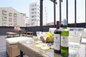 dwie butelki wina siedzące na stole na balkonie w obiekcie YADOYA Uguisu w Tokio