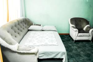a bed and a chair in a room at Апартаменты Кирова, 83 in Rakitnyy