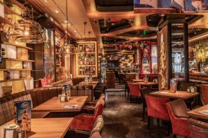 a restaurant with wooden tables and red chairs at The Stay by Aston Hotel Central Square - Free Compliments - Free Wi-Fi - TOP LOCATION - Nearby Paid Parking in Plovdiv