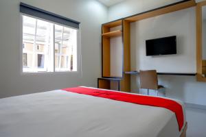 A bed or beds in a room at RedDoorz Syariah near Mutiara SIS Al Jufrie Airport Palu 2