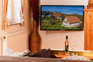 a living room with two vases and a tv on the wall at Kellerstöckl Goigner in Kitzeck im Sausal