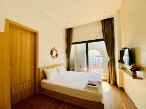 a bedroom with a bed and a large window at Vitamin Sea Homestay Nha Trang in Nha Trang