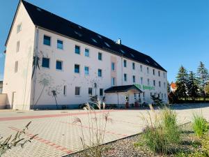 a large white building with a black roof at Hotel Bannewitz in Bannewitz