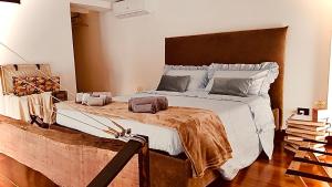1 dormitorio con 1 cama grande y cabecero de madera en Clementinam Suite Colosseum, en Roma