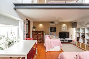 a living room with a couch and a tv at Akivillas Sesimbra Ocean in Lagoa de Albufeira