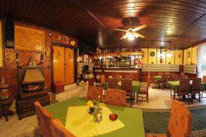 a restaurant with a table and chairs and a fireplace at Complex Turistic Caprioara in Baia Mare