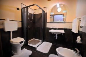 a bathroom with a shower and a toilet and a sink at Hotel Piccolo in Termini Imerese