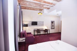 Zimmer mit einem Bett, einem Tisch und Stühlen in der Unterkunft Koszary Arche Hotel in Góra Kalwaria
