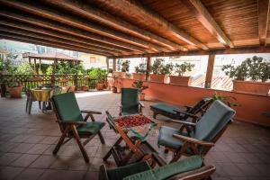 eine Gruppe von Stühlen und Tischen auf einer Terrasse in der Unterkunft Hotel Piccolo in Termini Imerese