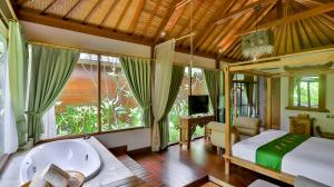 Schlafzimmer mit Badewanne, Bett und Fenster in der Unterkunft DISINI Luxury Spa Villas-CHSE Certified in Seminyak