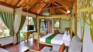 ein Schlafzimmer mit einem Bett und einem Fernseher in einem Zimmer in der Unterkunft DISINI Luxury Spa Villas-CHSE Certified in Seminyak