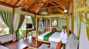 a bedroom with a bed and a tv in a room at DISINI Luxury Spa Villas-CHSE Certified in Seminyak
