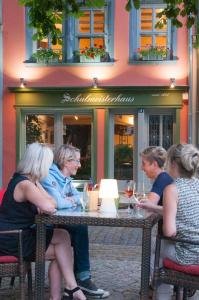 un gruppo di donne sedute a un tavolo con bicchieri da vino di Schulmeisterhaus a Naumburg