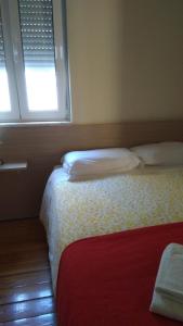 リスボンにあるIn the heart of Lisbonの小さなベッドルーム(ベッド2台、窓2つ付)が備わります。