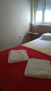 a bedroom with two white towels on a red bed at In the heart of Lisbon in Lisbon