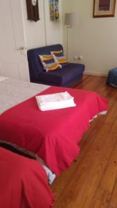 a bedroom with a red bed and a blue chair at In the heart of Lisbon in Lisbon