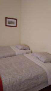 two beds in a bedroom with a picture on the wall at In the heart of Lisbon in Lisbon