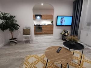 a living room with a flat screen tv and a table at Apartament Sobieski in Sanok