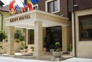 a restaurant with a sign on the front of a building at Griff Hotel Zalau in Zalău