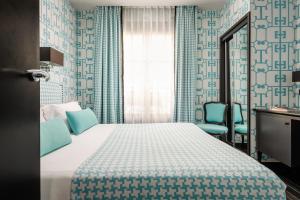 um quarto com uma cama e duas cadeiras azuis em Monceau Elysées em Paris