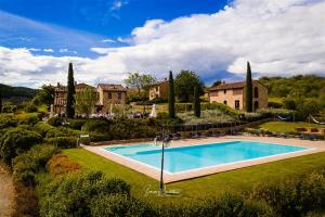 a large swimming pool in front of a house at Poggio Cennina Resort in Bucine