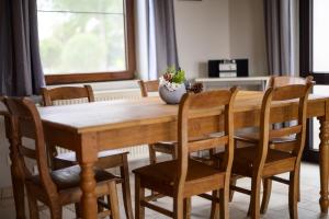 a dining room table with chairs and a vase on it at Les Terriers Saint-Hubert in Hatrival