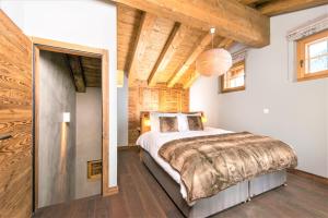 グリメンツにあるChalet Ourson Brun by Mrs Migginsの木製の天井が特徴のベッドルーム1室(大型ベッド1台付)