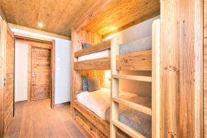 a bedroom with bunk beds in a log cabin at Chalet Ourson Brun by Mrs Miggins in Grimentz