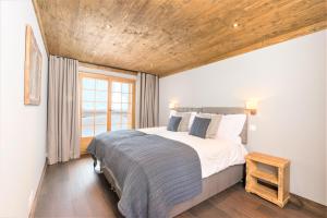 グリメンツにあるChalet Ourson Brun by Mrs Migginsの木製の天井のベッドルーム1室(大型ベッド1台付)