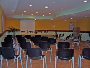 una stanza con un mucchio di sedie e un palco di Hotel Santa Caterina a Fisciano