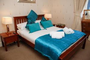 a bedroom with a large bed with blue pillows at BELL CRAIG GUEST HOUSE in Fife