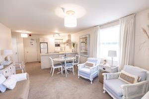 a living room with a table and chairs and a kitchen at Beach Break Escape 226 in Mount Maunganui