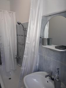 a bathroom with a sink and a shower with a mirror at Sport Apartman Tapolca in Tapolca +15 photos
