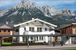 ein weißes Haus mit einem Berg im Hintergrund in der Unterkunft Martin Feyersinger in Ellmau