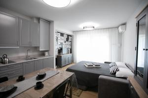 Donizetti Residence في بيرغامو: مطبخ وغرفة معيشة مع سرير وطاولة