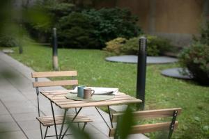 a wooden table with two chairs and a coffee mug on it at Donizetti Residence in Bergamo