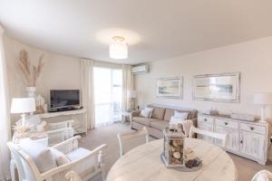 a living room with a couch and a table at Beach Break Escape 226 in Mount Maunganui