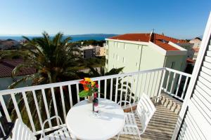 a table with a vase of flowers on a balcony at Apartments Marinko in Promajna