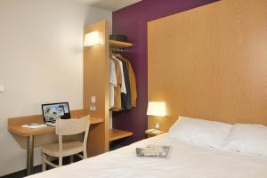 B&B HOTEL Lyon Caluire Cité Internationale tesisinde bir odada yatak veya yataklar