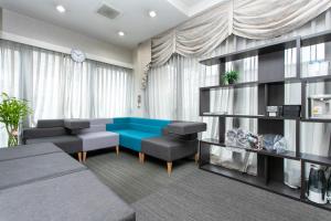 a living room with a blue couch and chairs at Tabist HotelArflex Tokuyama Station in Shunan