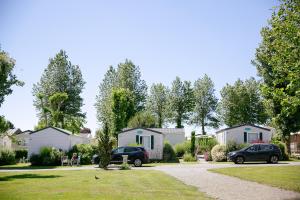 grupa domów i samochodów zaparkowanych na podjeździe w obiekcie Camping Saint Michel w mieście Courtils