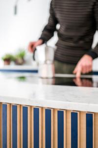 a person standing in a kitchen with a counter top at Wolken en Zout in Bredene