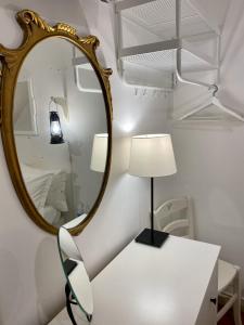 a mirror on a wall next to a table with a lamp at Al Ponte Del Papa B&B in Rome