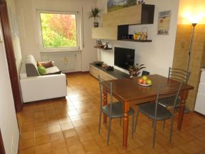 a kitchen and living room with a table and chairs at Appartamento Panoramico Lungopassirio in Merano