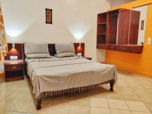 ein Schlafzimmer mit einem großen Bett und einer orangefarbenen Wand in der Unterkunft Marigold Guest House in Mombasa