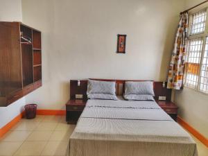a bedroom with two beds and two windows at Marigold Guest House in Mombasa