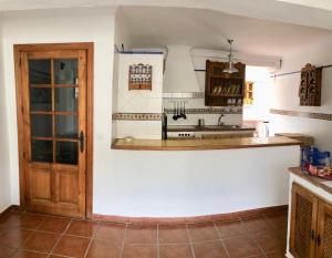 聖羅克的住宿－Piso en San Roque, centro neurálgico del Campo de Gibraltar，厨房设有白色的墙壁和木门。