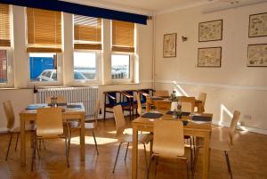 a dining room with tables and chairs and windows at The Aqua in Portland